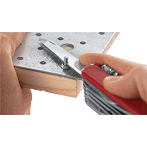 Swiss Army Knife SAK cutting metal on iron and wood with screw