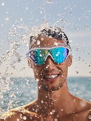 man smiling wearing arena The One swim mask goggle for adults at the beach on a sunny day